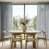 Light blue sheer custom curtains with linen texture, light filtering.